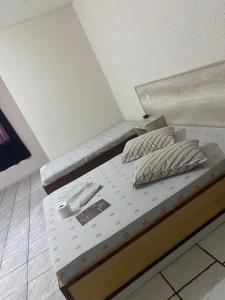 a bed with two pillows on it in a room at Hospedaria São Mateus in São Paulo +1 photo
