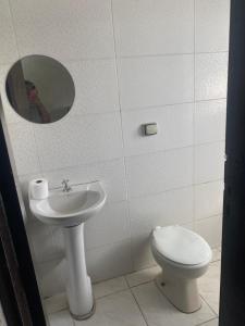 a bathroom with a toilet and a sink and a mirror at Hospedaria São Mateus in São Paulo