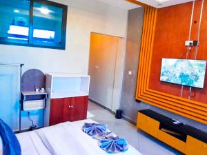 a bedroom with a bed and a tv on the wall at RIVANA HOTEL Goba in Dar es Salaam