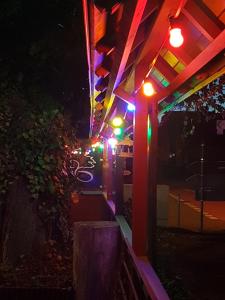 a lit up pergola at night with colorful lights at Esskastanie - Pension und Restaurant in Twiste