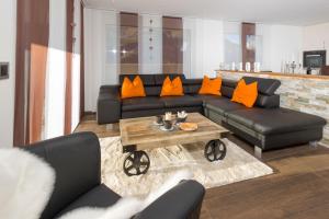 ein Wohnzimmer mit einem schwarzen Sofa und einem Tisch in der Unterkunft Milleggapark Casa Mia in Grächen