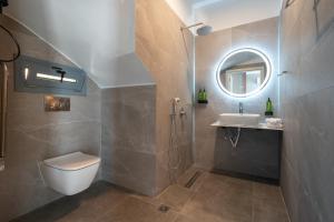 a bathroom with a toilet and a sink and a mirror at Aithra Lemnos in Thános