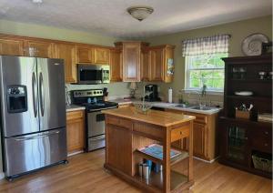 a kitchen with wooden cabinets and a stainless steel refrigerator at High Cotton in Leesburg