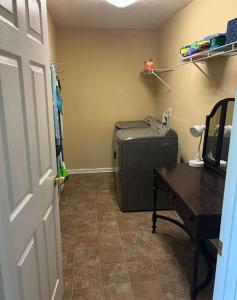 a room with a desk and a suitcase and a table at High Cotton in Leesburg