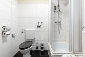 a white bathroom with a toilet and a shower at Hotel an der Hörn in Kiel +37 photos