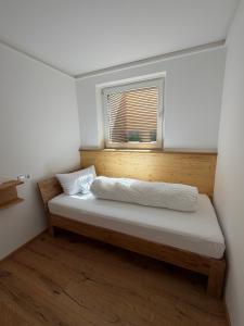 a bed in a room with a window at Ferienwohnung Andreas in Holzkirchen