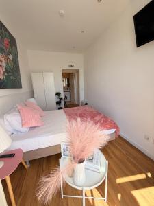 a bedroom with a bed and a table with a phone at Naval Guest House in Vila do Conde