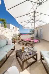 a patio with a table and an umbrella at Jakov & Antonia Heritage Estate in Hvar