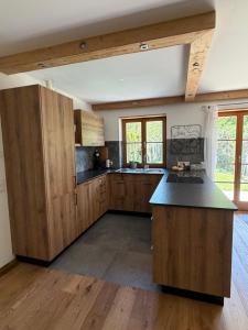 a kitchen with wooden cabinets and a black counter top at Ferienwohnung Andreas in Holzkirchen