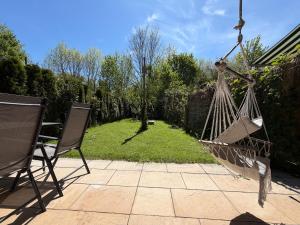 a hammock in a garden with a table and chairs at Ferienwohnung Andreas in Holzkirchen