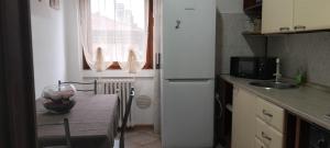 a small kitchen with a table and a refrigerator at Adda House in Trezzo sullʼAdda