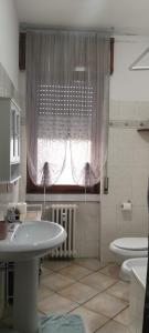 a bathroom with a sink and a toilet and a window at Adda House in Trezzo sullʼAdda
