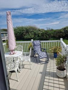eine Terrasse mit zwei Stühlen, einem Tisch und einem Sonnenschirm in der Unterkunft Maise's in Camber