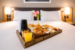 a tray of food and drinks on a bed at Quality Hotel & Suites Brasília in Brasília +68 photos