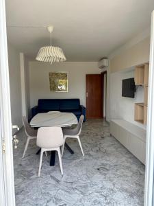 a living room with a table and chairs and a couch at Elba Essence Suites in Portoferraio