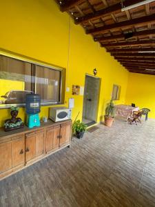 a living room with a yellow wall and a table at Pousada Imperatriz in Aparecida
