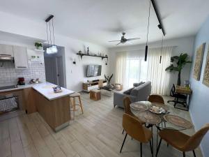 a kitchen and living room with a table and chairs at Private Beach Community - White Sands Golf Resort - Modern 2BR Private Pool and Patio in Punta Cana