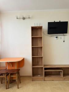 a room with a book shelf and a tv on a wall at Promenad San in Dobrovelychkivka
