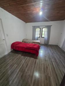 a bedroom with a bed with a red blanket at El descanso in Veronica