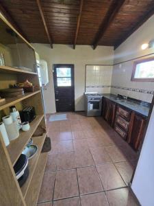 a large kitchen with a tile floor and wooden ceilings at El descanso in Veronica