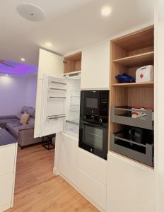 a small kitchen with white cabinets and a microwave at Apartamento Luxe Triana in Seville
