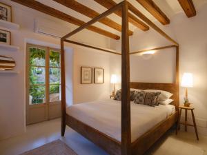 a bedroom with a four poster bed and a window at Can 'Jeson in Deia +70 photos