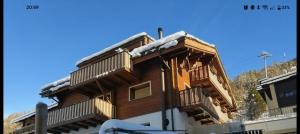 a log cabin with snow on the roof at Chalet Adler in Grächen