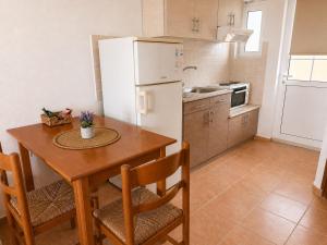 a kitchen with a table and a white refrigerator at Τηλεμαχος Apartments in Loutra Edipsou