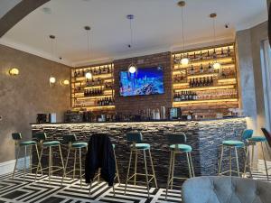 a bar with green stools in a restaurant at The Gungate Hotel - Cocktails and Wine Bar in Tamworth