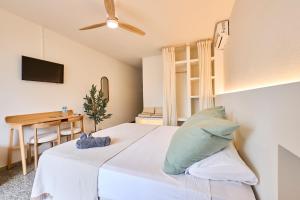 a bedroom with a white bed and a desk at Hotel S'Algaret in Fornells