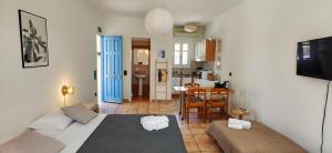 ein Schlafzimmer mit einem Bett und ein Wohnzimmer und eine Küche in der Unterkunft Marvia Studios in Vourkari