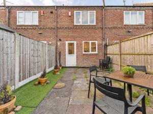 a backyard with a wooden fence and a table and chairs at The Derby Escape - Garden -Sleeps 6 in Derby