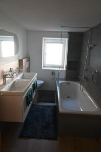 a bathroom with a tub and a sink and a bath tub at Ferienwohnung "Posta Veglia" - Cumbel in Cumbels +9 photos