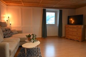 a living room with a couch and a tv at Ferienwohnung "Posta Veglia" - Cumbel in Cumbels