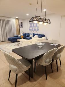 a dining room and living room with a table and chairs at Premium 2 Bedroom Apartment Near Airport in Muscat
