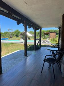 a wooden deck with two chairs and a pool at Shulgivka in Shulʼgovka