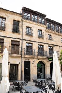 a building with tables and umbrellas in front of it at Ando Apartments Boutique in Salamanca
