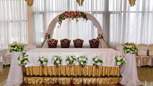 a wedding altar with flowers on a bed at Edelweiss in Almaty
