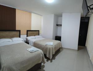 a hotel room with two beds and a tv at Hotel the Blue House in Ipiales +7 photos