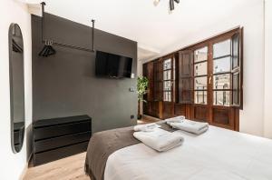 a bedroom with a large bed with towels on it at Ando Apartments Boutique in Salamanca