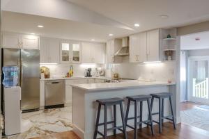 a kitchen with white cabinets and a counter with stools at The Great Escape in Clintondale