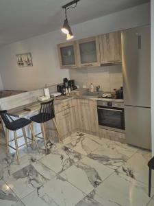 a kitchen with a counter and chairs and a refrigerator at Ionian Balcony II in Athani