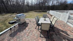 a patio with a grill and a table and chairs at The Great Escape in Clintondale