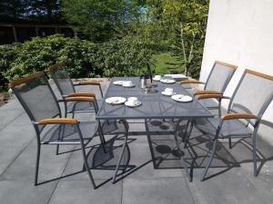 a glass table and chairs sitting on a patio at Ferienhaus Bielefeld in Bielefeld