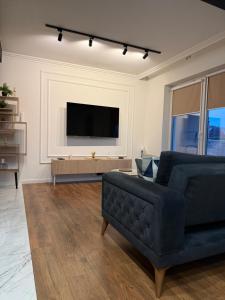 a living room with a couch and a flat screen tv at Katerina - Mona Luxury Apartments in Lębork
