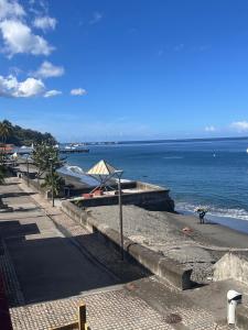 a sidewalk next to a beach with the ocean at Hotel Ti' Pelican in Saint-Pierre +5 photos