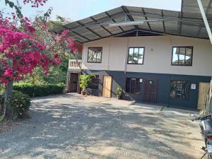 a house with a flowering tree in front of it at Hotel Don Roberto in San Isidro de El General