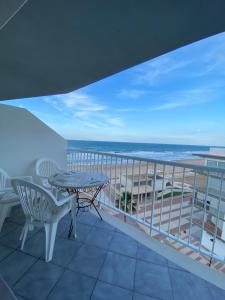 a balcony with a table and chairs and a view of the ocean at Apartamento con vistas a la Playa con Ascensor y WIFI 9 pax in Daimuz