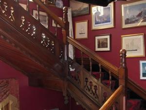 a staircase in a room with pictures on the wall at Villa Rothsay Hotel in Cowes