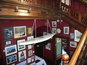 a chandelier hanging from a red wall with pictures at Villa Rothsay Hotel in Cowes